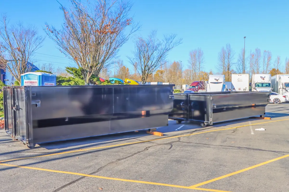 Professional dumpster rental service with roll-off container on residential driveway in Champlain